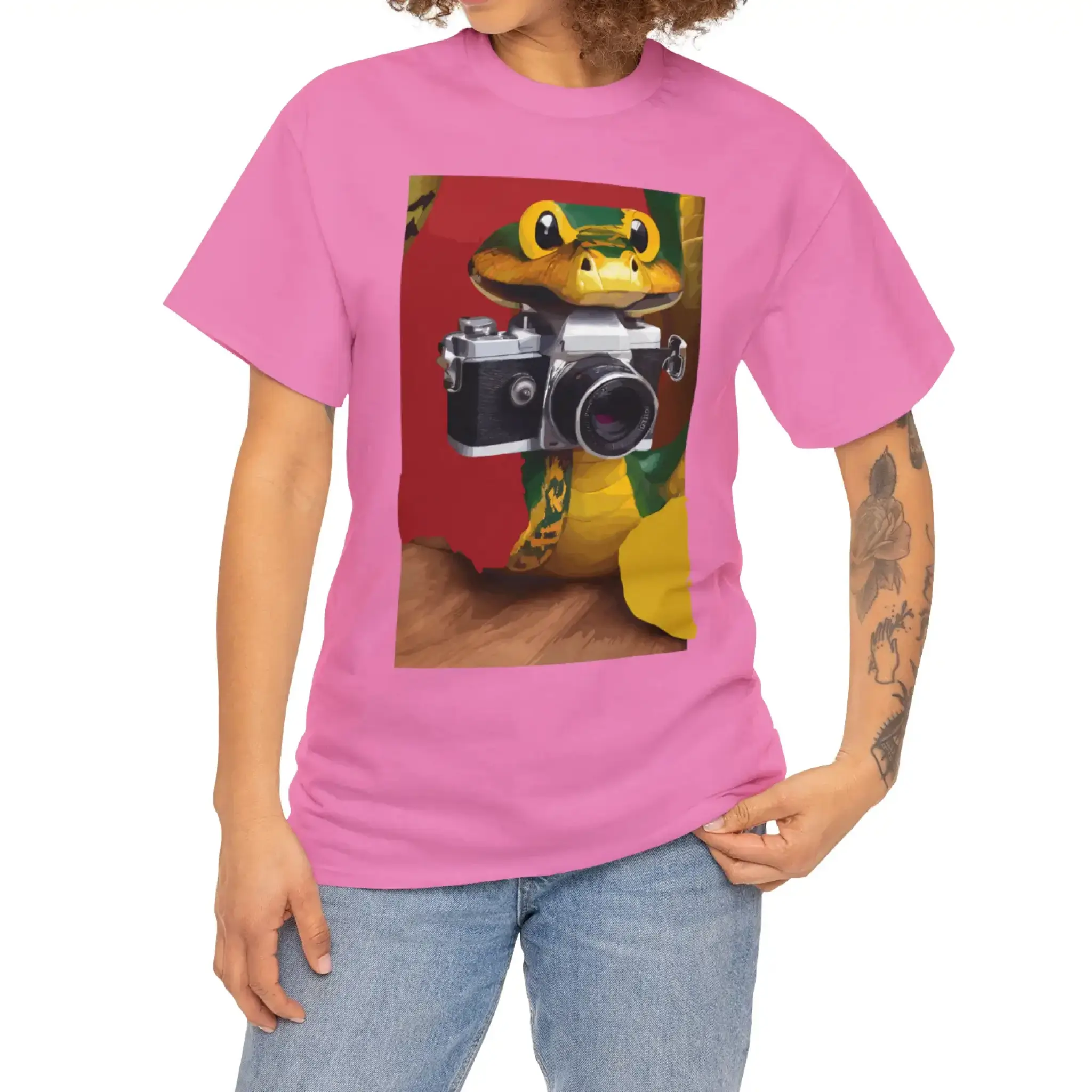 A woman in a pink t-shirt featuring a snake camera graphic. She's smiling and enjoying her day outdoors.