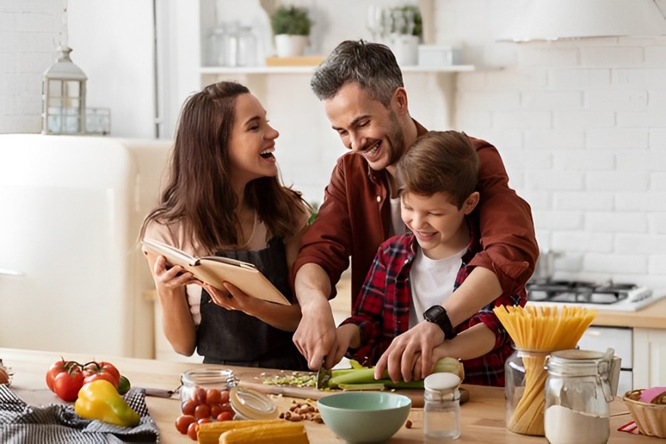 A family joyfully prepares food together in a warm, inviting kitchen, showcasing their culinary skills and teamwork.